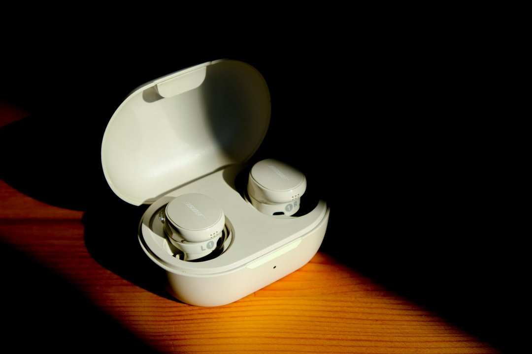 Detaliu cu o pereche de earbuds pentru alergare rezistente la transpirație în carcasa lor