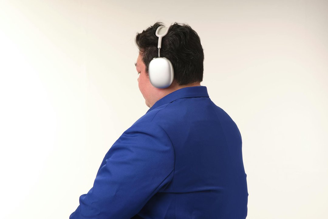 Bărbat concentrat la birou purtând căști bluetooth over-ear cu anulare activă a zgomotului