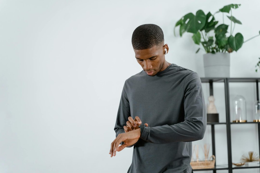 Bărbat utilizând funcțiile unui smartwatch pentru bărbați la sală, verificând progresul după un exercițiu.