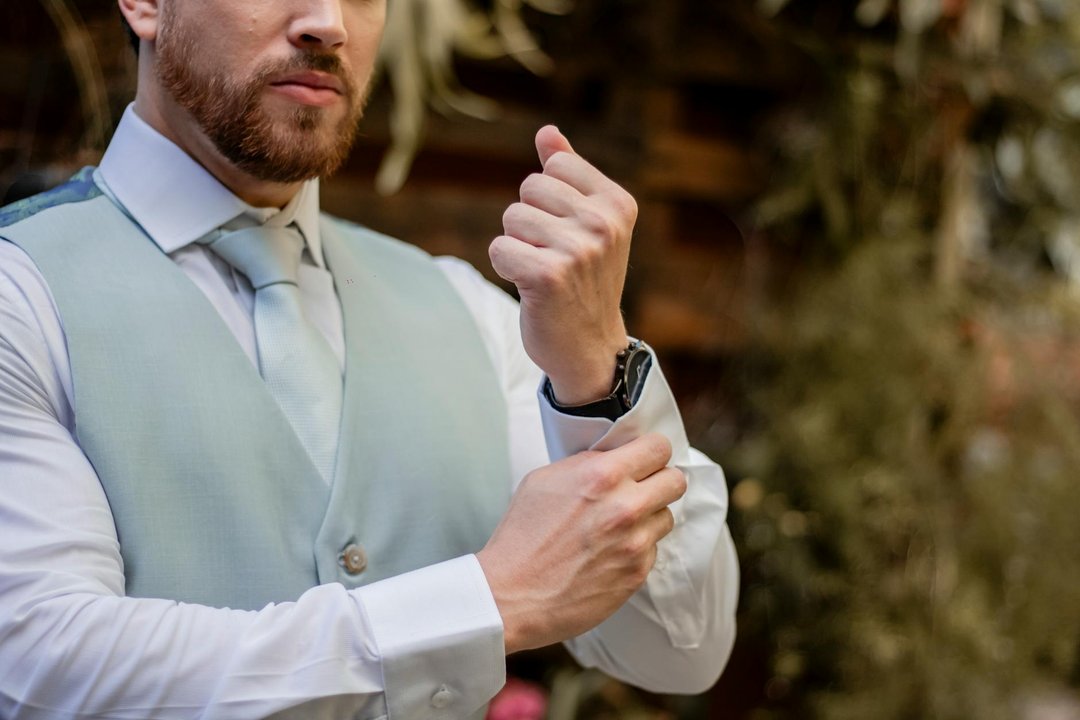 Bărbat elegant ajustând o curea metalică la un ceas smartwatch la birou