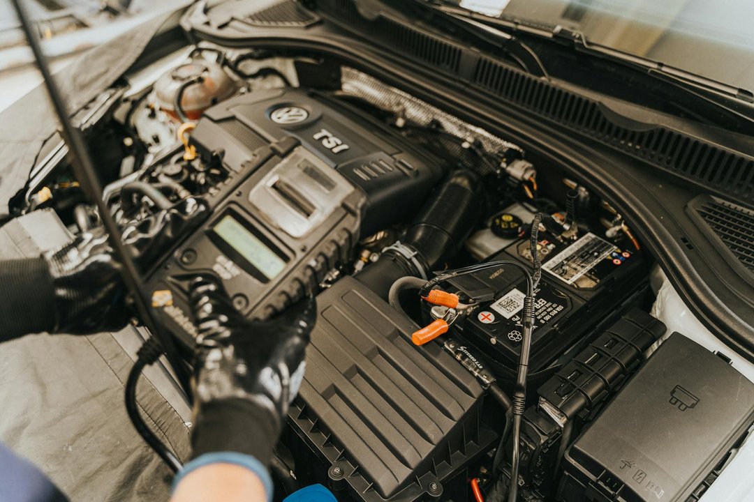 Mecanic specializat efectuează o diagnoza auto profesionala la motorul unei mașini.
