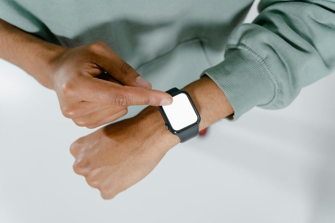 Imagine de aproape cu aplicarea unei folii de protecție de tip hidrogel pe un ecran de smartwatch.