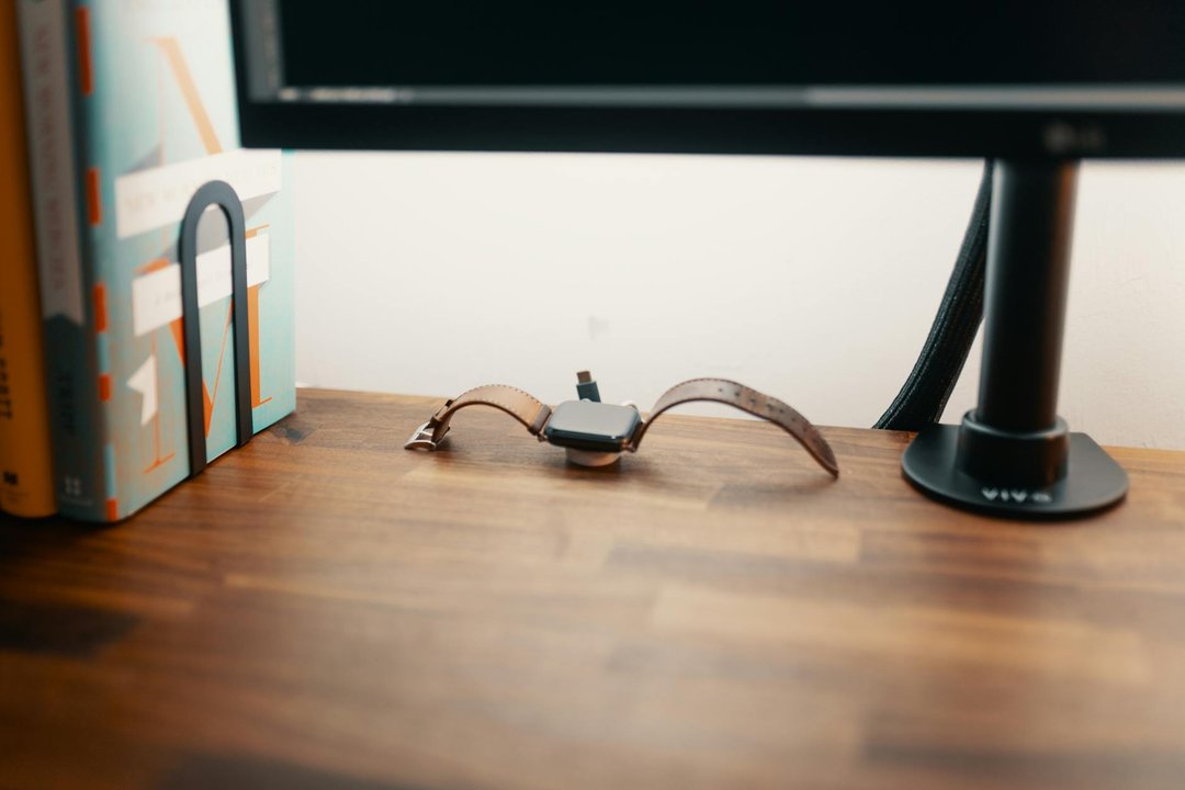 Dock de încărcare elegant pentru smartwatch așezat pe o noptieră modernă din lemn