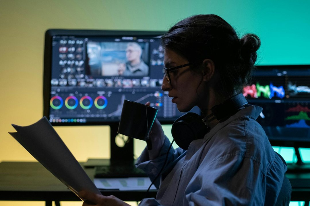 Creator de conținut concentrat, editând un video cu căști profesionale, parte din kitul esențial pentru 2026.