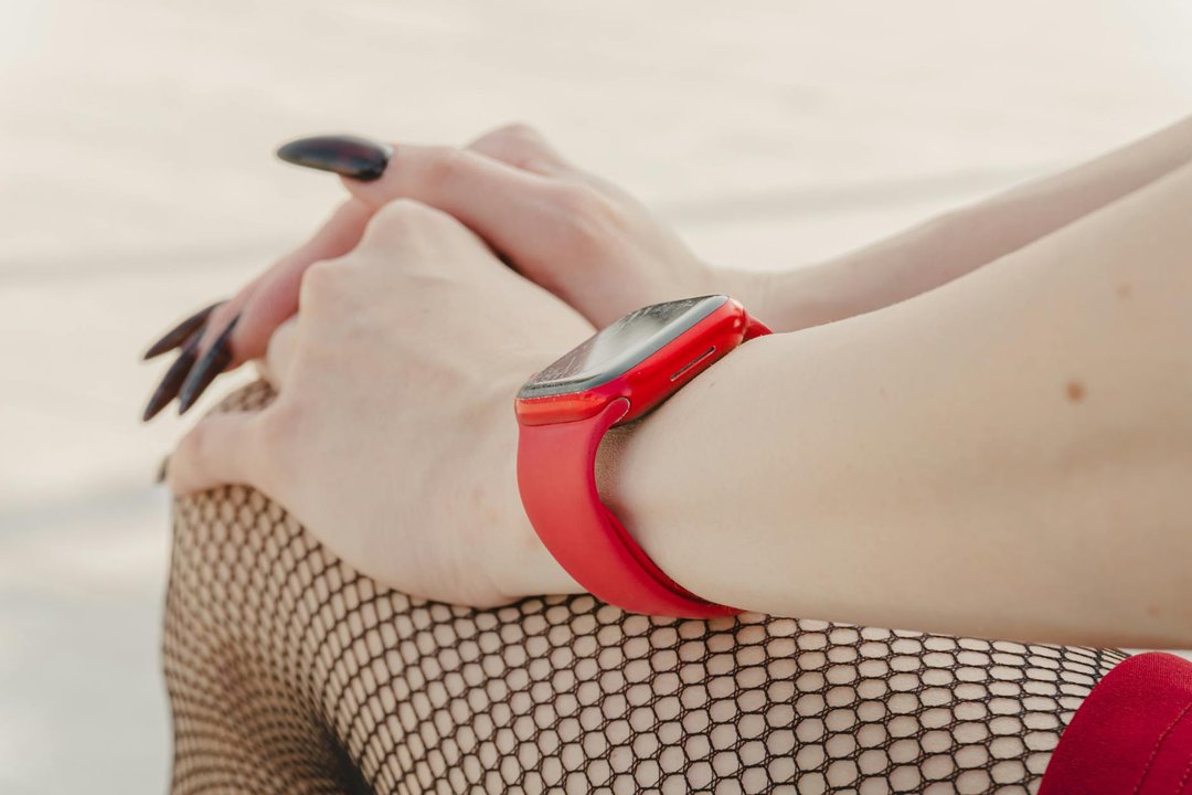 Un smartwatch elegant femei de culoare aurie purtat la încheietura unei doamne într-un cadru urban.