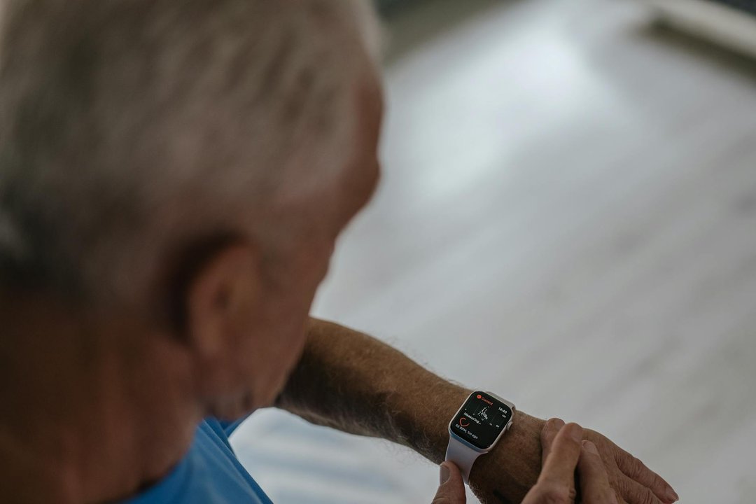 Un smartwatch pentru varstnici cu ecran mare afișând iconița de apel, purtat de un bunic zâmbitor la încheietura mâinii.